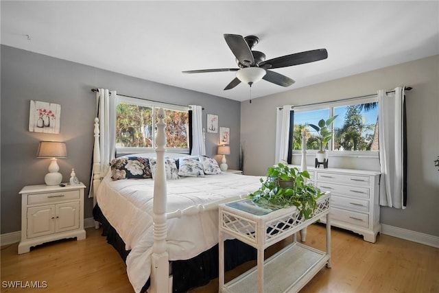 bedroom featuring multiple windows, light wood-style flooring, baseboards, and ceiling fan