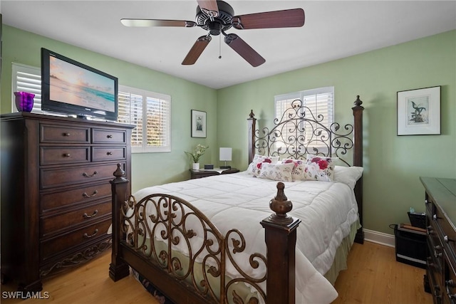 bedroom with light wood finished floors, ceiling fan, and baseboards