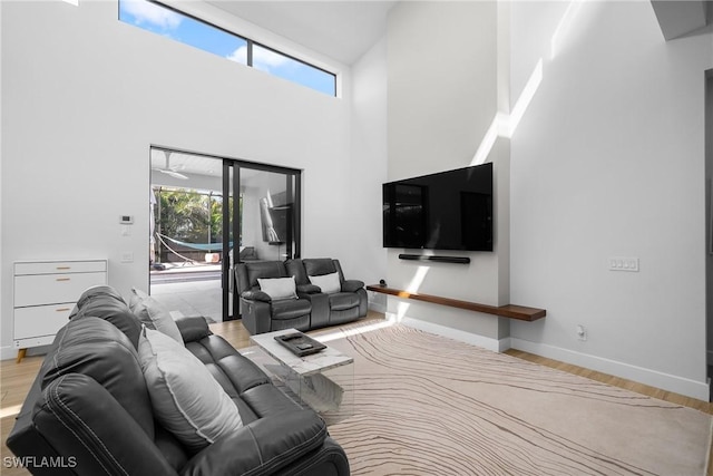 living room featuring a wealth of natural light, baseboards, and wood finished floors