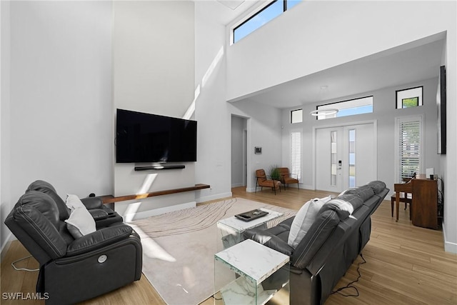 living area featuring a wealth of natural light, baseboards, and wood finished floors