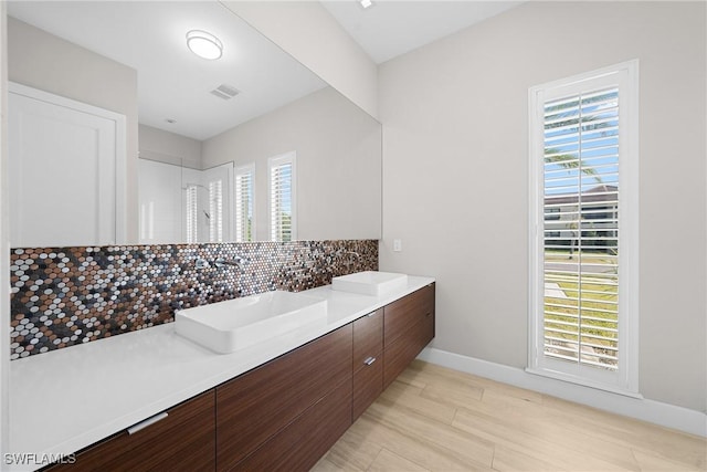 bathroom featuring a sink, plenty of natural light, and tasteful backsplash