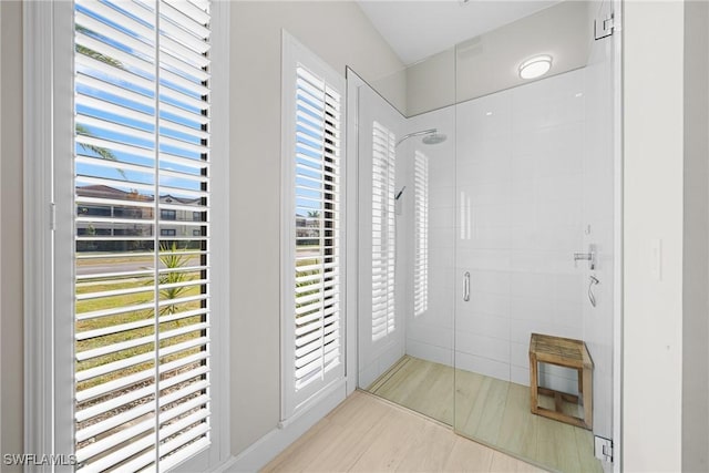 full bathroom with a stall shower and wood finished floors