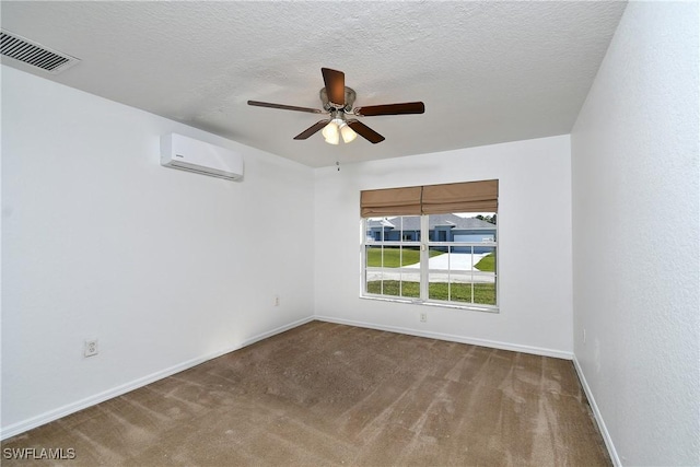 spare room with visible vents, carpet, an AC wall unit, a textured ceiling, and a ceiling fan