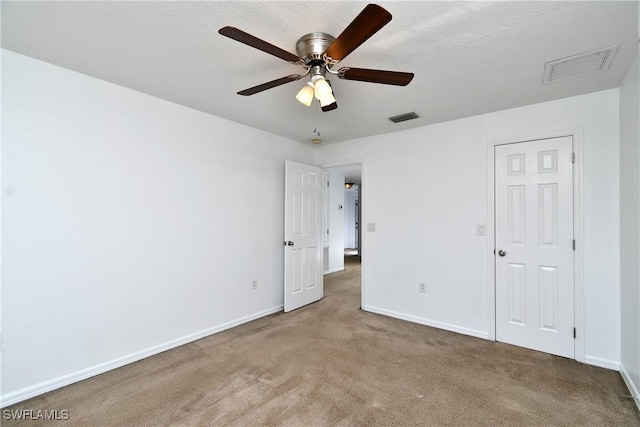 unfurnished bedroom featuring visible vents, baseboards, carpet, and a ceiling fan