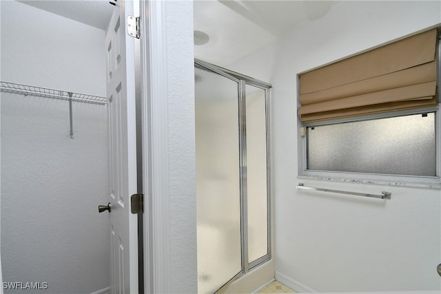 full bath featuring a stall shower and baseboards