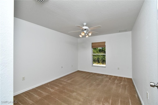 carpeted empty room with visible vents, baseboards, a textured ceiling, and ceiling fan