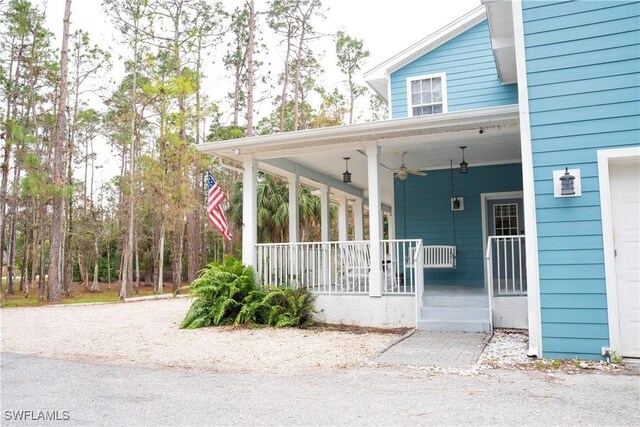 exterior space featuring a garage, a porch, and ceiling fan