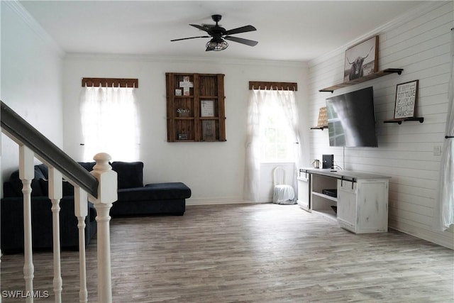 living room featuring a wealth of natural light, light wood-type flooring, and ornamental molding