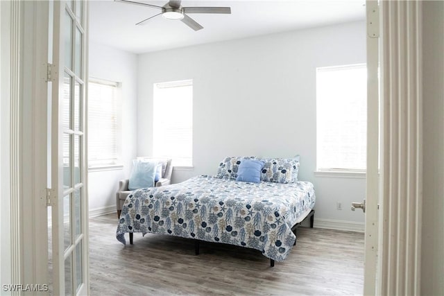 bedroom with baseboards, wood finished floors, and a ceiling fan