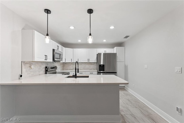 kitchen with visible vents, tasteful backsplash, stainless steel appliances, a peninsula, and light countertops