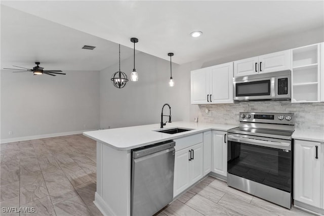 kitchen featuring visible vents, backsplash, appliances with stainless steel finishes, a peninsula, and a sink