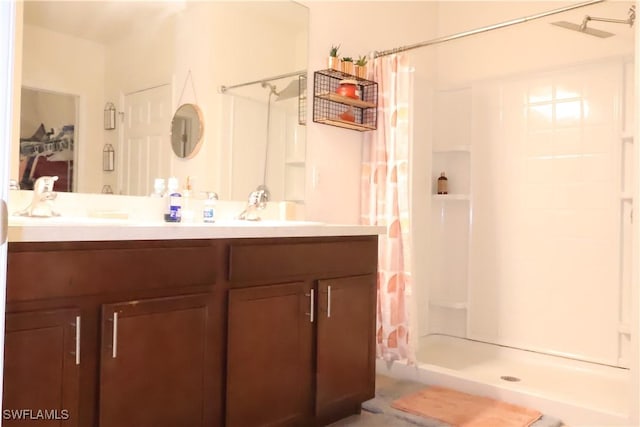 bathroom featuring double vanity, a stall shower, and a sink