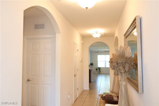 hall featuring light tile patterned floors and visible vents