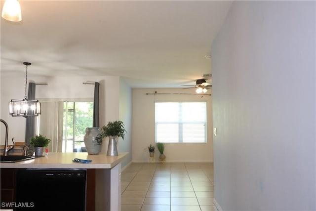 interior space with ceiling fan, light countertops, black dishwasher, light tile patterned flooring, and a sink