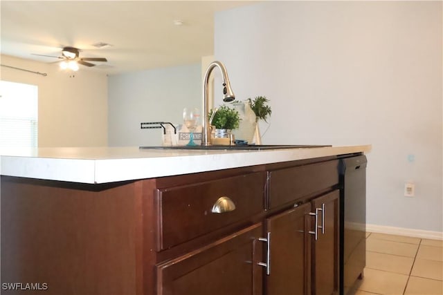 bar with a sink, light tile patterned floors, baseboards, dishwasher, and ceiling fan