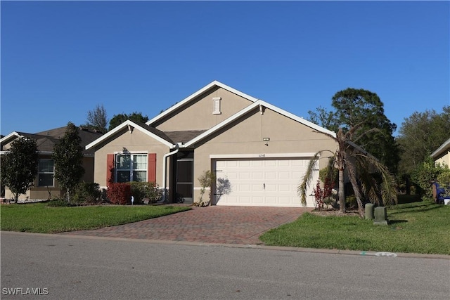 ranch-style home featuring stucco siding, decorative driveway, an attached garage, and a front yard