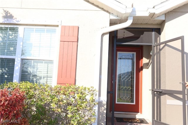 doorway to property featuring stucco siding