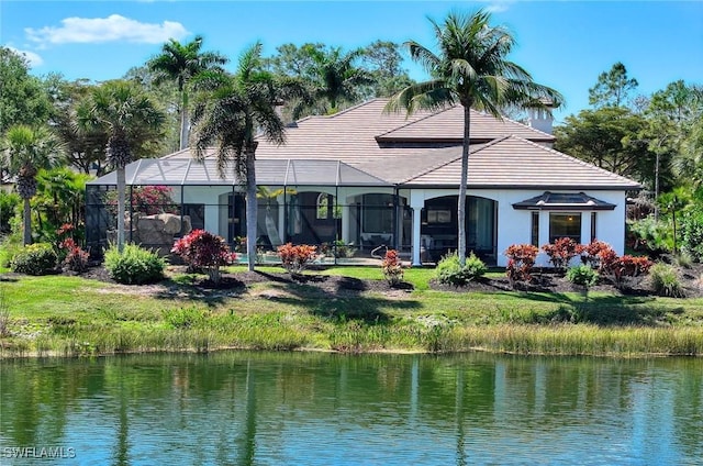 back of property with a lanai, stucco siding, and a water view