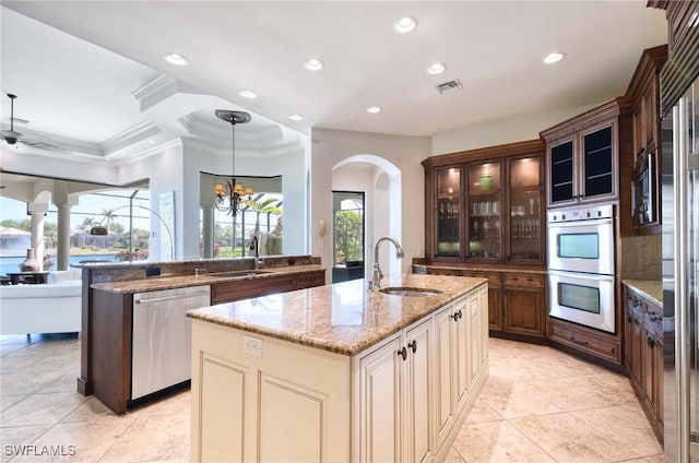 kitchen featuring arched walkways, recessed lighting, stainless steel appliances, and a sink