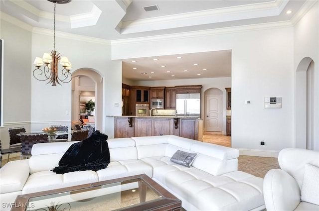 living area featuring crown molding, a notable chandelier, light tile patterned flooring, and arched walkways