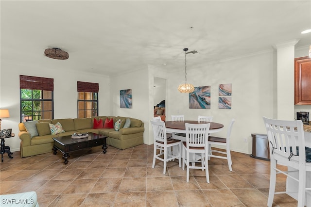 dining room with crown molding, a notable chandelier, visible vents, and light tile patterned floors