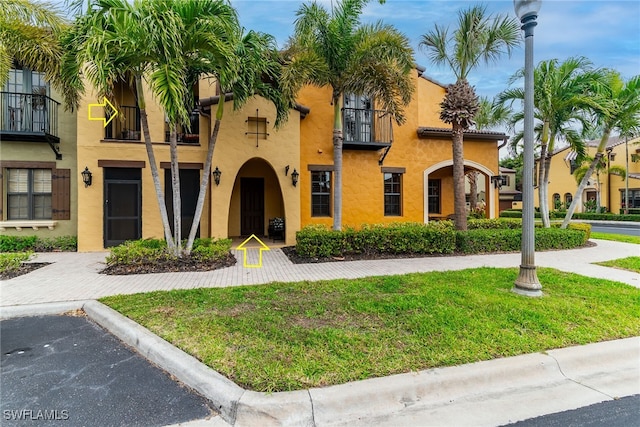 view of front facade with stucco siding and a front yard