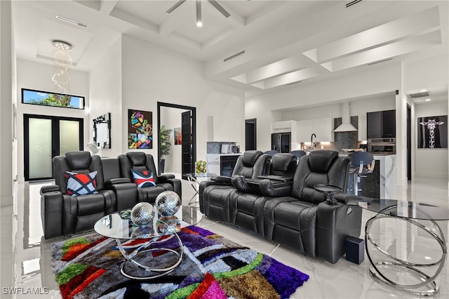 home theater with beam ceiling, marble finish floor, coffered ceiling, and a high ceiling