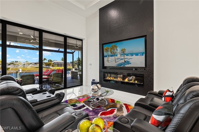 living area with a glass covered fireplace and a ceiling fan