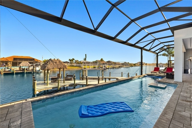 outdoor pool featuring glass enclosure, a water view, boat lift, and a dock