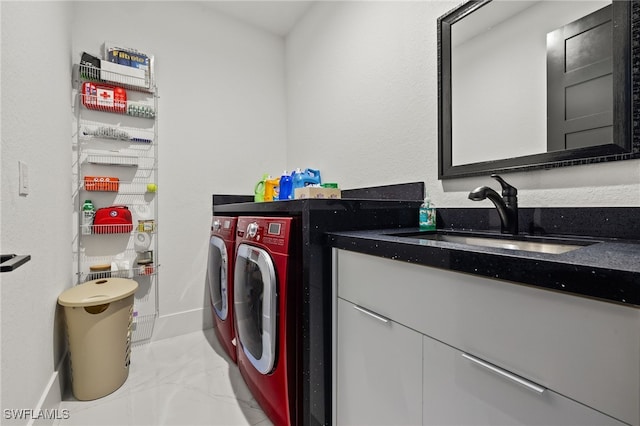 laundry area featuring washing machine and clothes dryer, marble finish floor, and a sink