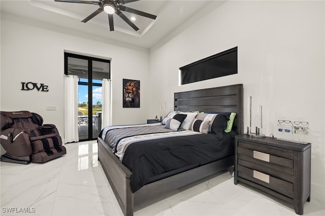 bedroom featuring access to exterior, marble finish floor, a raised ceiling, and ceiling fan