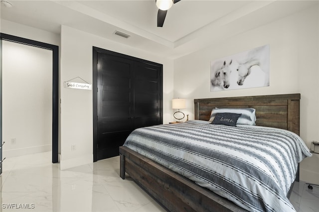 bedroom with visible vents, marble finish floor, a ceiling fan, a tray ceiling, and baseboards