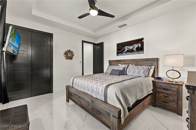 bedroom featuring visible vents, baseboards, ceiling fan, marble finish floor, and a raised ceiling