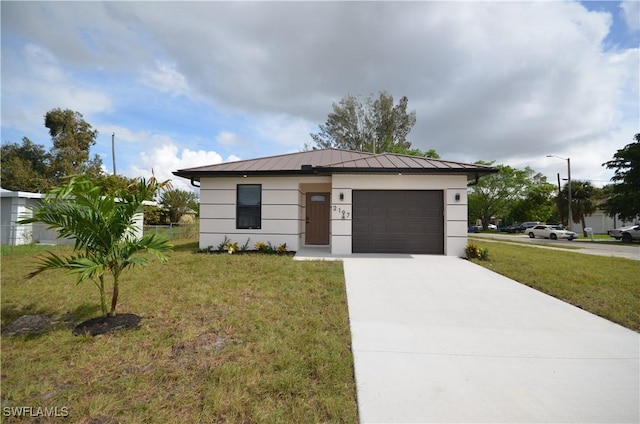 view of front of property featuring a front yard, driveway, a standing seam roof, a garage, and metal roof