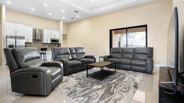 living area with recessed lighting, visible vents, and baseboards