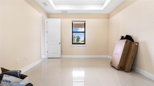 unfurnished room featuring a tray ceiling, visible vents, baseboards, and marble finish floor