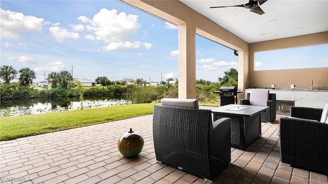 view of patio / terrace with area for grilling, ceiling fan, and a water view