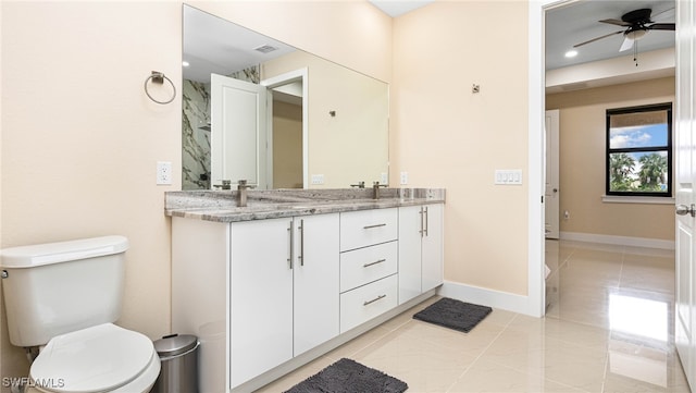 bathroom with visible vents, ceiling fan, baseboards, toilet, and double vanity