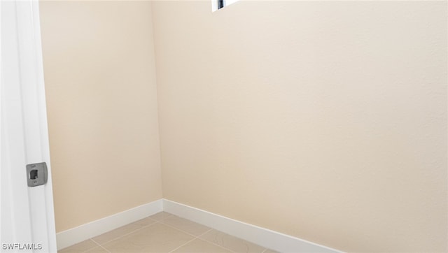 washroom with light tile patterned floors, baseboards, and laundry area