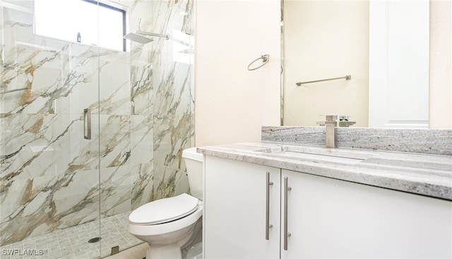 bathroom featuring a marble finish shower, toilet, and vanity