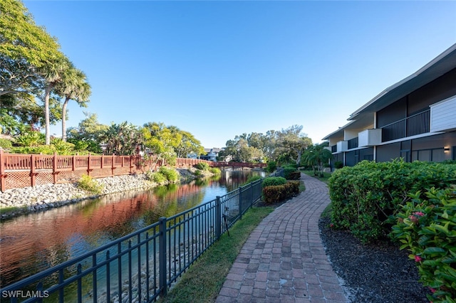 view of property's community with a water view and fence