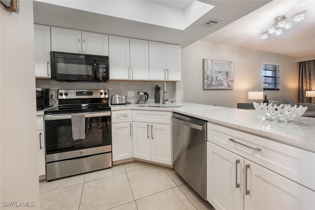 kitchen featuring tasteful backsplash, visible vents, white cabinets, stainless steel appliances, and a sink