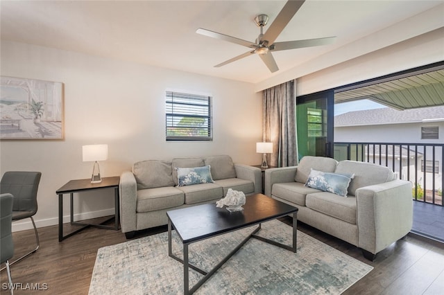 living room featuring baseboards, ceiling fan, and dark wood-style flooring