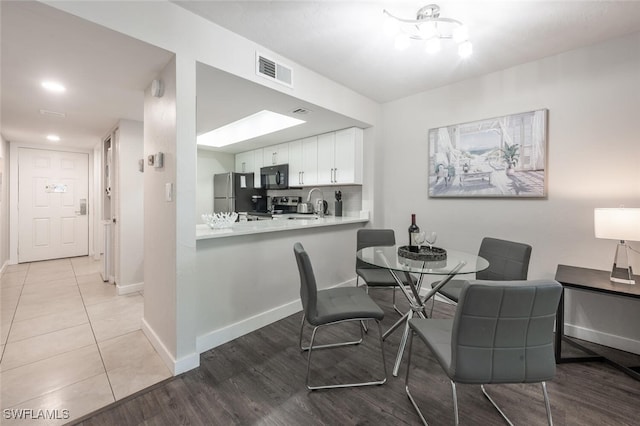 dining room featuring visible vents, baseboards, and wood finished floors