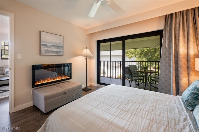 bedroom with access to outside, a glass covered fireplace, dark wood finished floors, baseboards, and ceiling fan