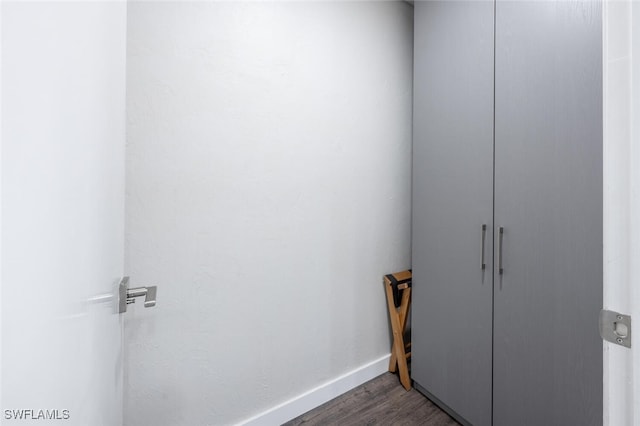 laundry area featuring baseboards and wood finished floors