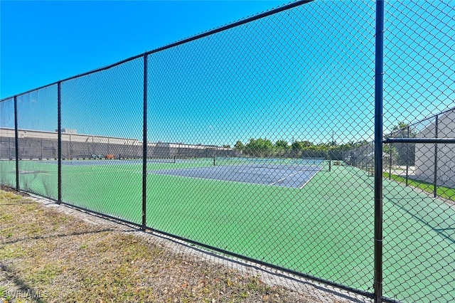 view of tennis court featuring fence