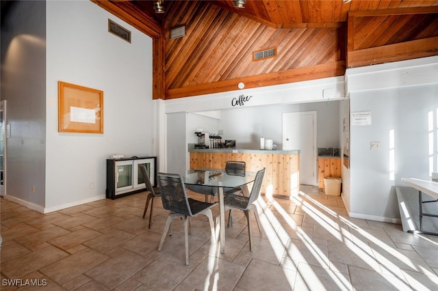 dining area featuring wooden ceiling, baseboards, and high vaulted ceiling