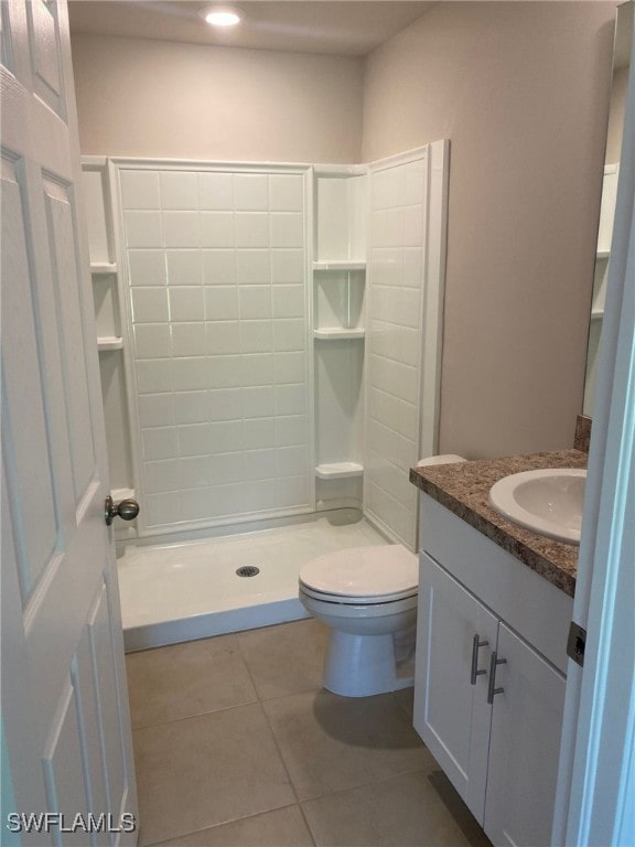 full bathroom featuring vanity, tile patterned floors, toilet, and a shower stall