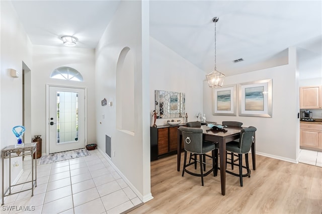 foyer with light tile patterned flooring, baseboards, visible vents, and a chandelier